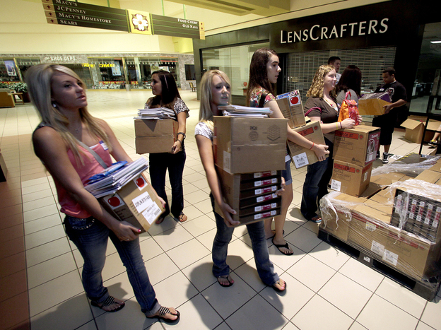 Students carry donated supplies to a classroom on the first day of school at a temporary high school in a converted big-box store in Joplin, Mo., last August. School started on time in the district nearly three months after an EF-5 tornado devastated much of the city and killed 161 people.