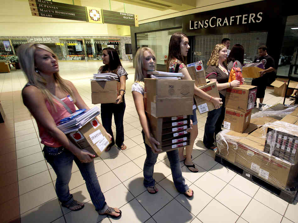 Students carry donated supplies to a classroom on the first day of school at a temporary high school in a converted big-box store in Joplin, Mo., last August. School started on time in the district nearly three months after an EF-5 tornado devastated much of the city and killed 161 people.