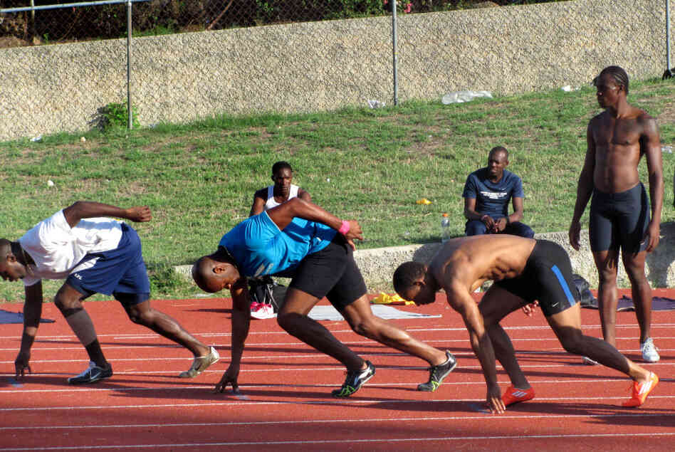 Top Jamaican sprinters, including Olympic gold medalist Asafa Powell (in blue), practice at Kingston's National Stadium on one of the country's few synthetic tracks.