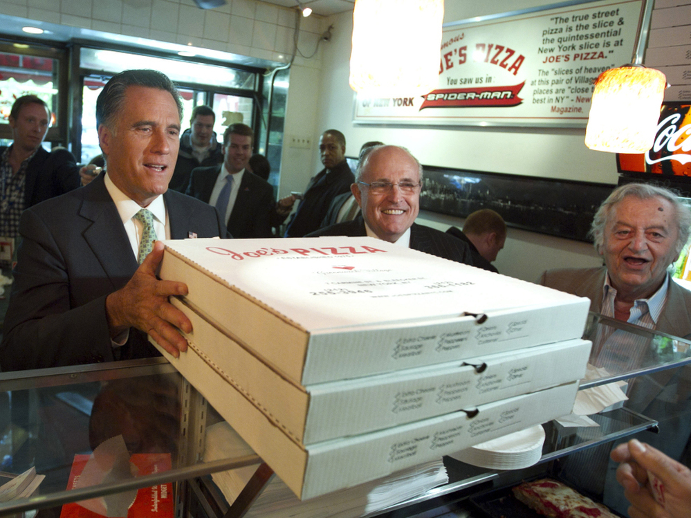 The same day President Obama made a surprise trip to Afghanistan, Mitt Romney picked up pizza for firefighters with former New York City Mayor Rudolph Giuliani.