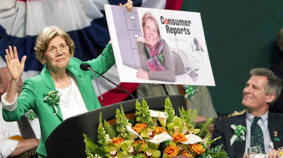 Democratic Senate candidate Elizabeth Warren holds up a poster of herself as Sen. Scott Brown, R-Mass., looks on during the annual St. Patrick's Day Breakfast in Boston on March 18. A civility pledge between the candidates has kept attack ads largely on the sidelines in their race.