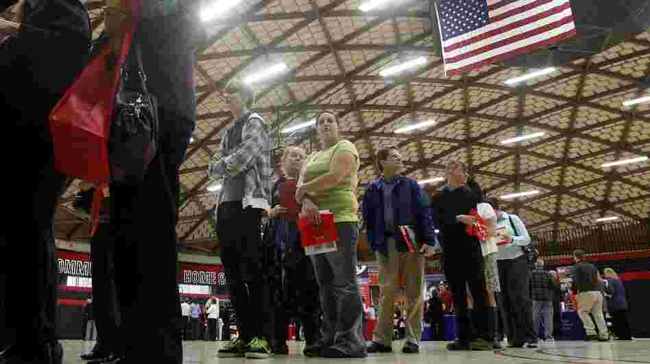 People wait in a line at a job fair on April 10, 2012, in Gresham, Ore. Employment grew by 115,000 last month, but the unemployment rate dip was likely due to people leaving the workforce rather than people getting hired, analysts say.