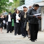 People seeking jobs wait in line to speak to employers at a career fair Thursday in the Queens borough of New York.