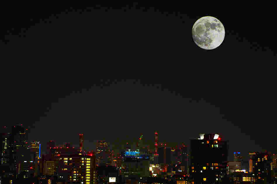 The moon shines bright over Tokyo, Japan. 