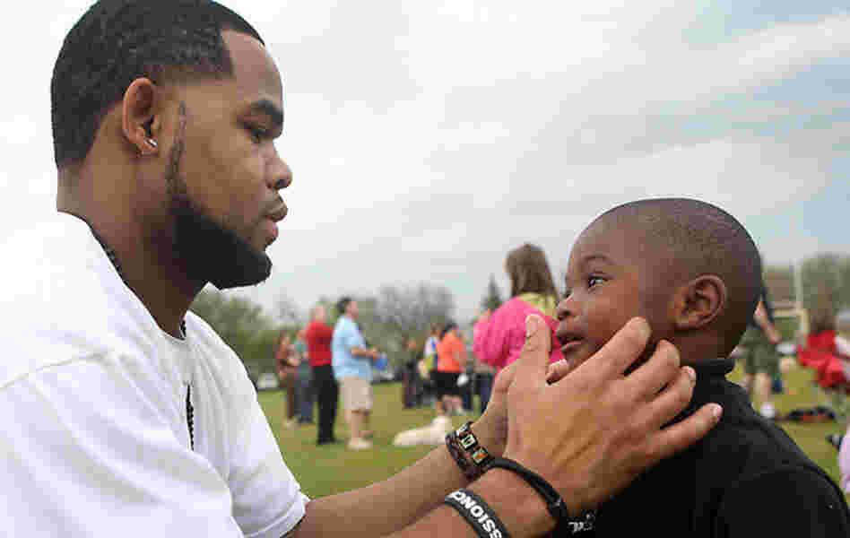 Joseph Arradondo assists his son Nasir, 2, on the sidelines of his daughter's soccer game in Brooklyn Park, Minn. Arradondo attended Co-Parent Court about a year ago and says the court helped with communication between him and Nasir's mother.