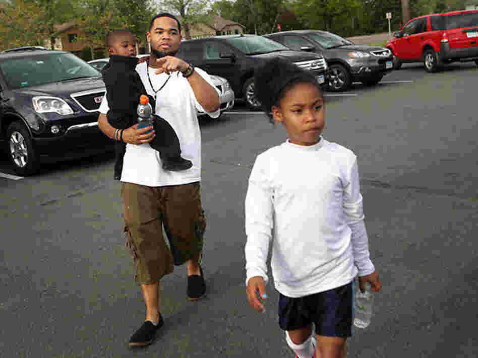 Joseph Arradondo walks with son Nasir, 2, and daughter Nevaeh, 9, before Nevaeh's soccer game.