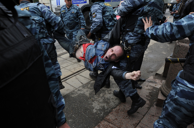 Police officers carry an anti-Putin protester, who was detained in central Moscow, on Monday.