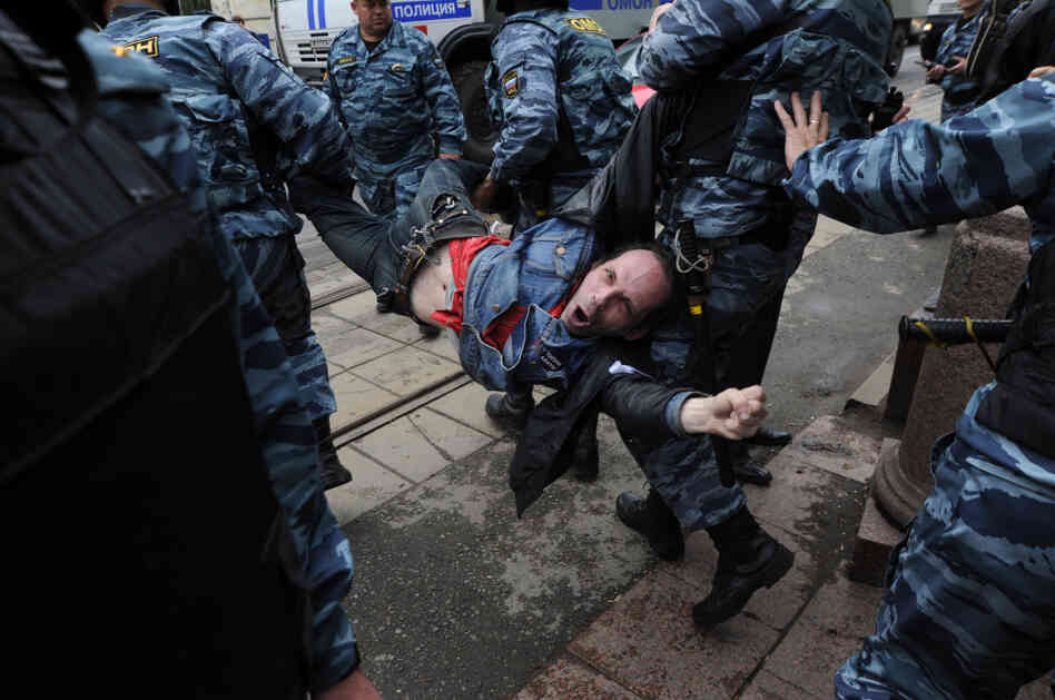 Police officers carry an anti-Putin protester, who was detained in central Moscow, on Monday.