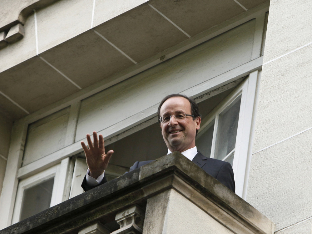 President-elect Francois Hollande waves from a Socialist Party headquarters balcony in Paris Monday May 7, 2012.
