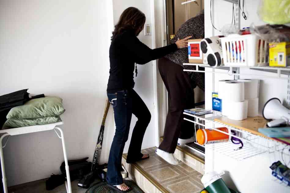 Kelley supports AnnaBelle as she goes up the steps entering her family's home. AnnaBelle's mobility is significantly hampered owing to rheumatoid arthritis.