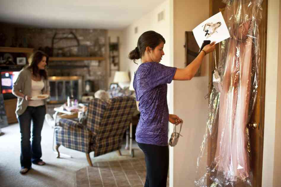 Kelley's daughter Carley, 17, looks at her prom dress while Kelley tends to AnnaBelle. By next year, Kelley and her husband will have two daughters in college.