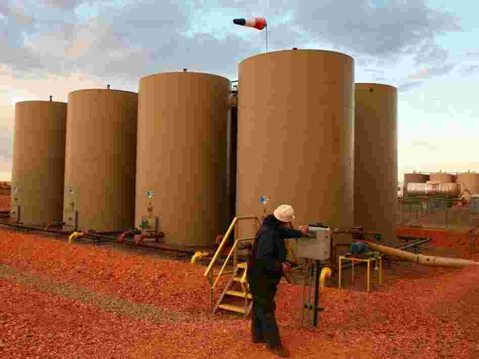 U.S. oil production is at its highest level in decades. Here a worker transfers oil into a container tank outside Alexander, N.D., in October 2011.