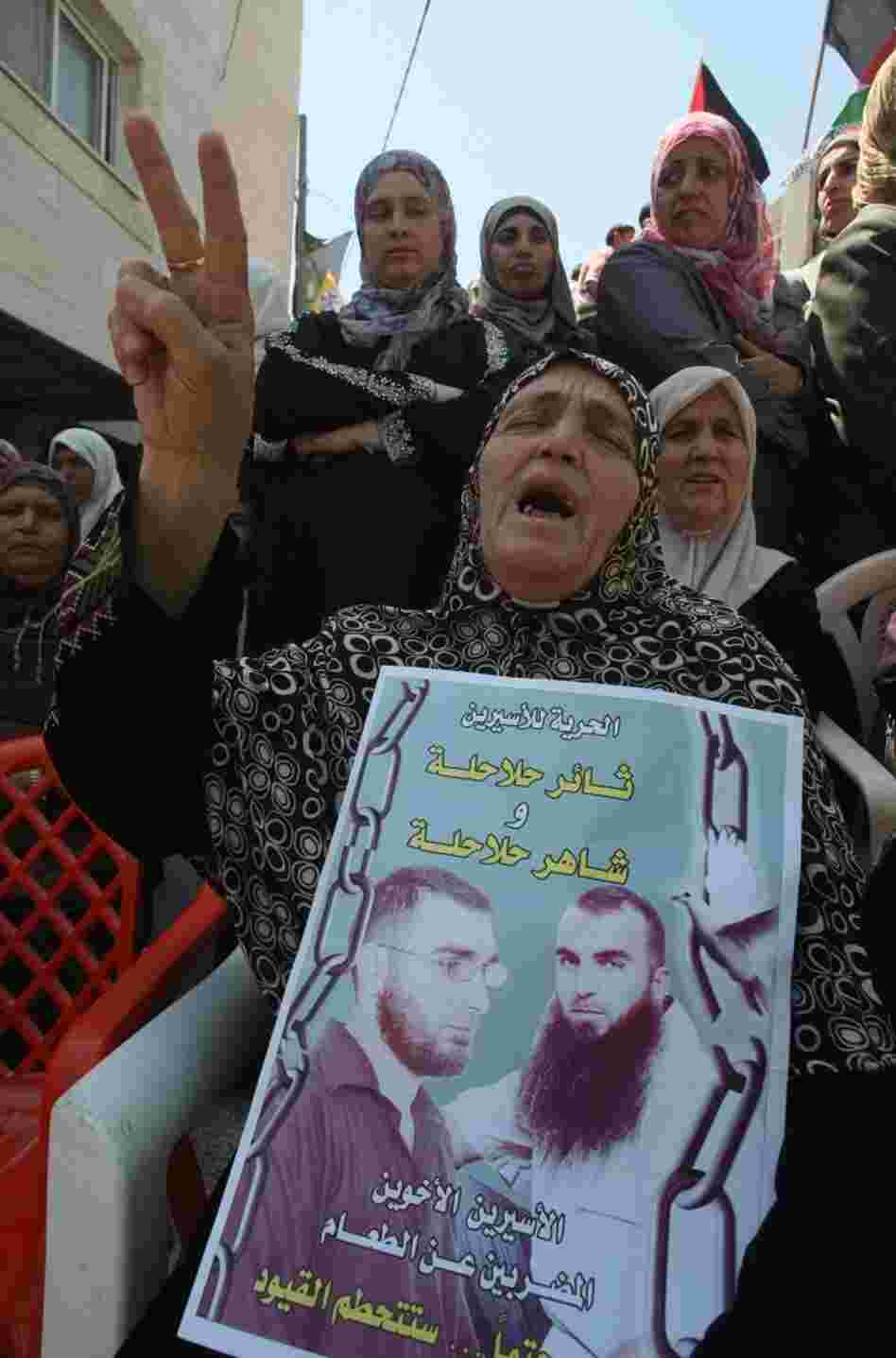 A Palestinian woman holds pictures of jailed relatives during a demonstration in the West Bank city of Hebron on Tuesday, May 8. Palestinians are protesting in solidarity with some 1,500 prisoners on hunger strike who are demanding an end to Israel's practice of detention without trial as well as more frequent family visits, among other issues.