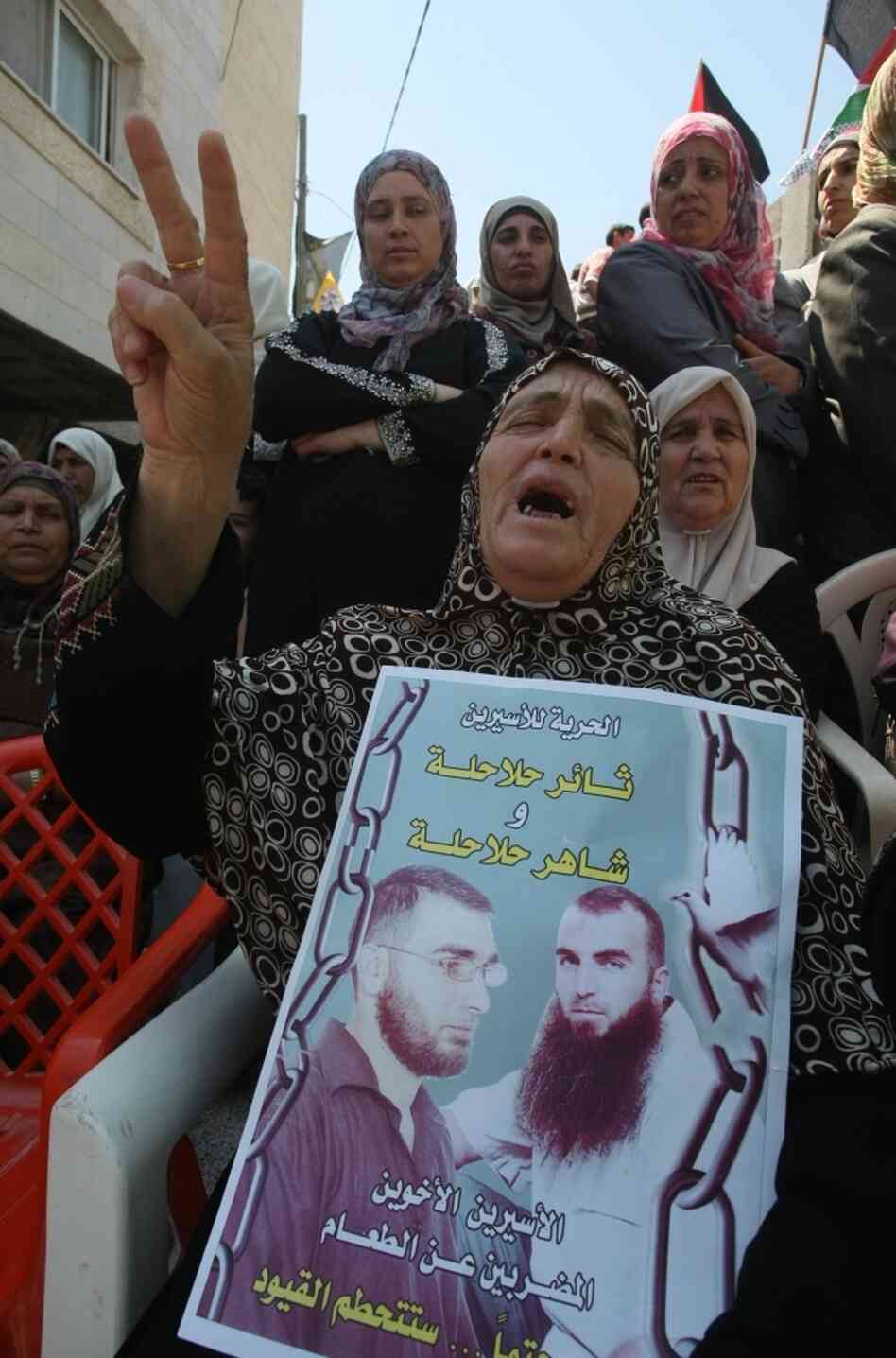 A Palestinian woman holds pictures of jailed relatives during a demonstration in the West Bank city of Hebron on Tuesday, May 8. Palestinians are protesting in solidarity with some 1,500 prisoners on hunger strike who are demanding an end to Israel's practice of detention without trial as well as more frequent family visits, among other issues.