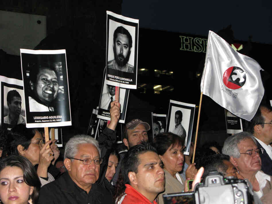 Mexicans hold up posters of journalists who have been killed in recent years, at a recent vigil in Mexico City.