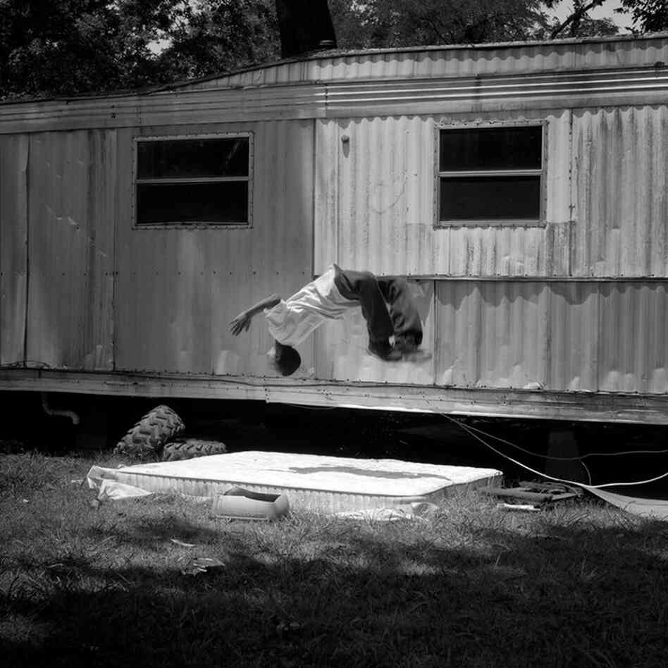 A young boy performs a back flip on a discarded mattress in his grandfather's backyard in Duncan, June 2011.