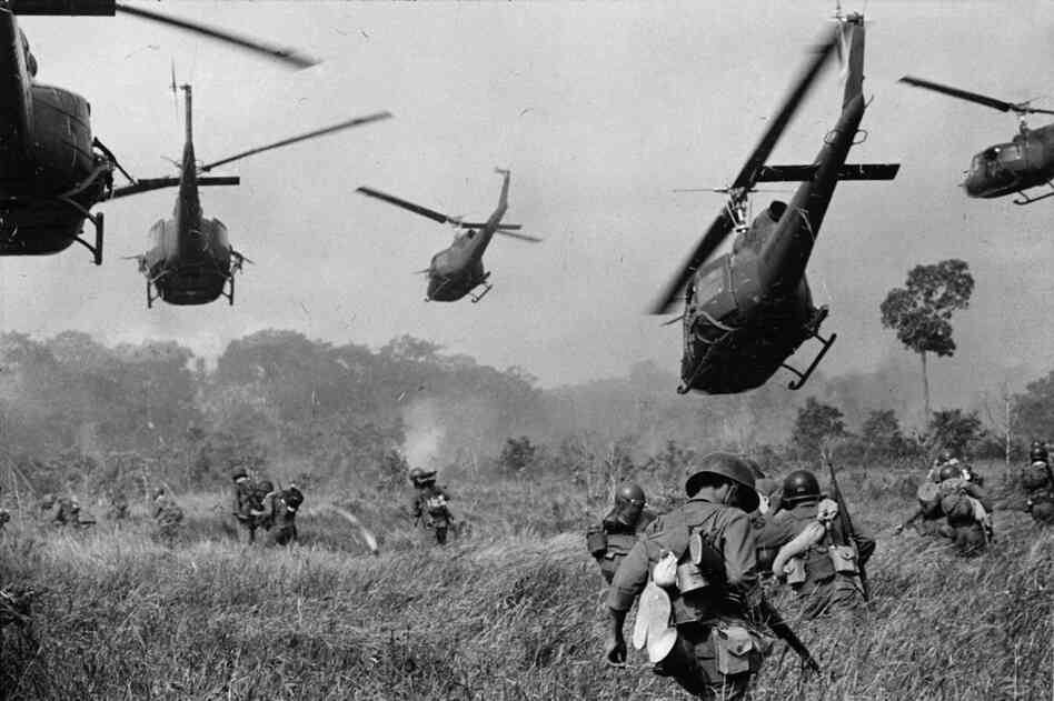 Hovering U.S. Army helicopters pour machine-gun fire into the tree line to cover the advance of South Vietnamese ground troops in an attack on the Viet Cong, March 1965.