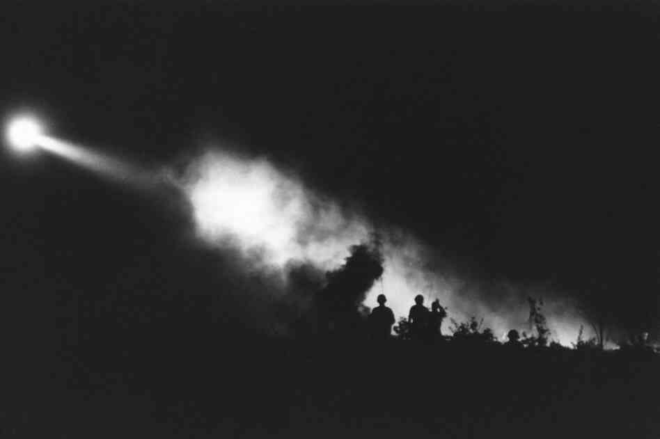 Landing light from a medical evacuation helicopter cuts through the smoke of battle for Bu Dop, South Vietnam, November 1967.