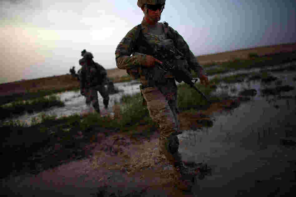 Sgt. Matthew McMurray walks through a flooded riverbed while on a joint operation.