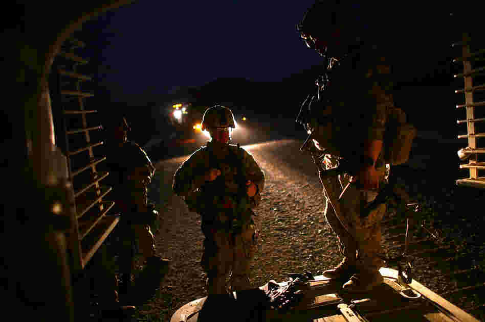 U.S. soldiers stand at the rear door to their armored vehicle after an all-day patrol with the Afghan National Army.