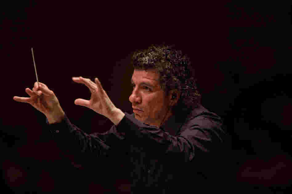 Like the other four conductors in Ives' massive symphony, music director Giancarlo Guerrero wears earbuds to hear the click track needed to keep all the musicians playing together.