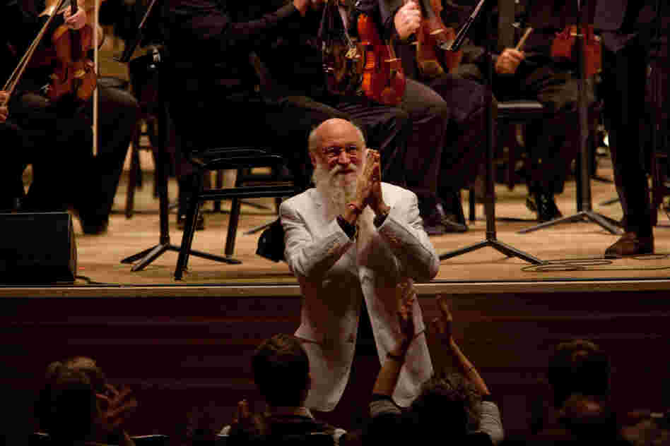 Terry Riley accepting enthusiastic applause. He said that his concerto "leaped into my consciousness as a very spontaneous work, full of the things in music that I find colorful, dynamic, beautiful, challenging, humorous, loving, friendly, joyous, stark and universally minded."