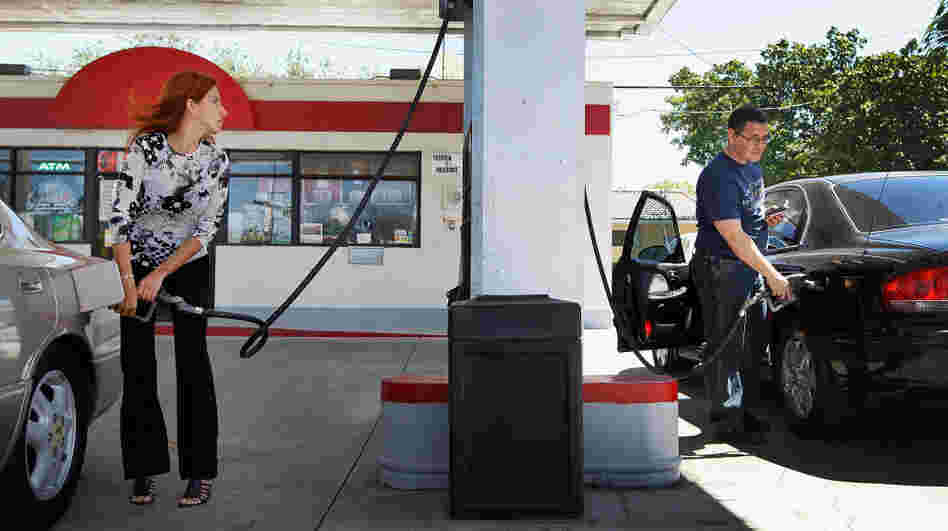 Mayeli Vasallo (left) and Jorge Monte pump gas in Miami in April. The average price of a gallon of gas has dropped 20 cents in the last month, to $3.73.