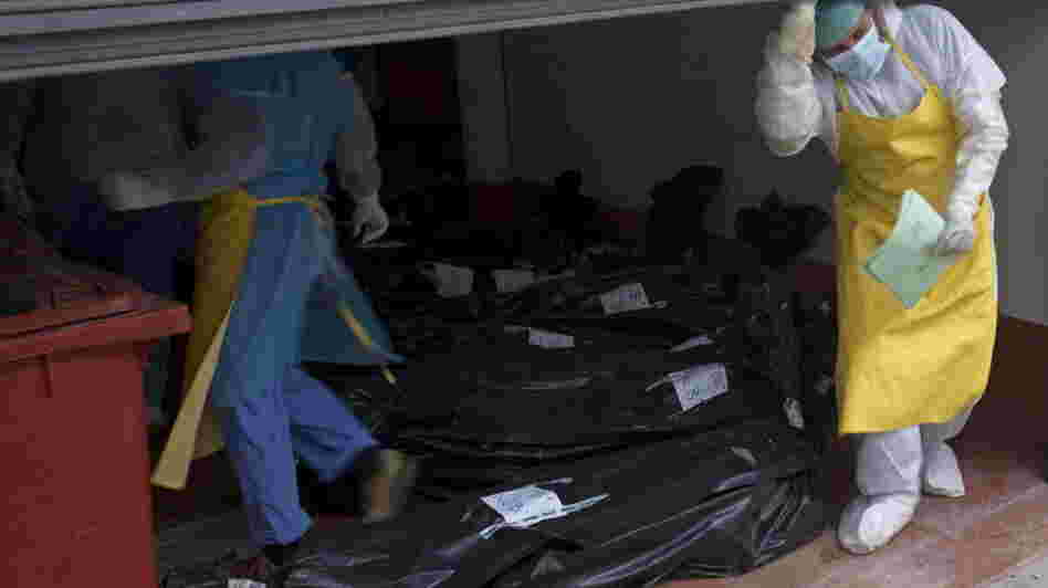 Morgue employees take in some of the bodies that were found Sunday.