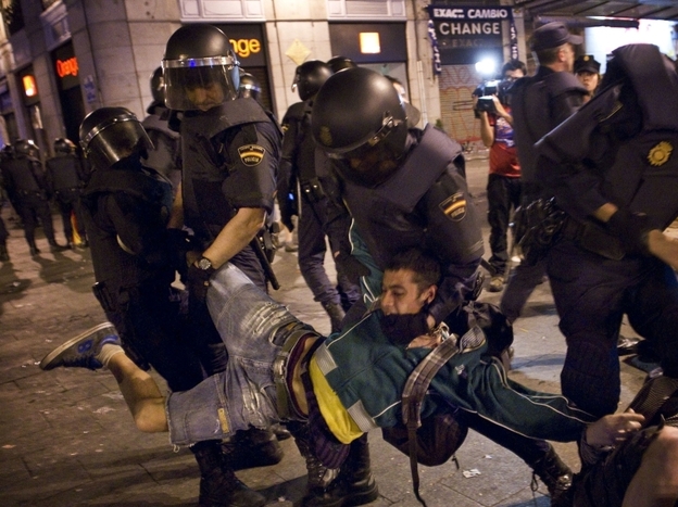 Spanish police officers carry off a demonstrator as he and others are evicted from a square in Madrid on Sunday.