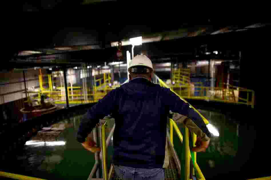 A worker crosses over a water-holding and skimming tank. In 2008, Eureka modified its technology to clean up the peculiar mix of gunk in frack water.