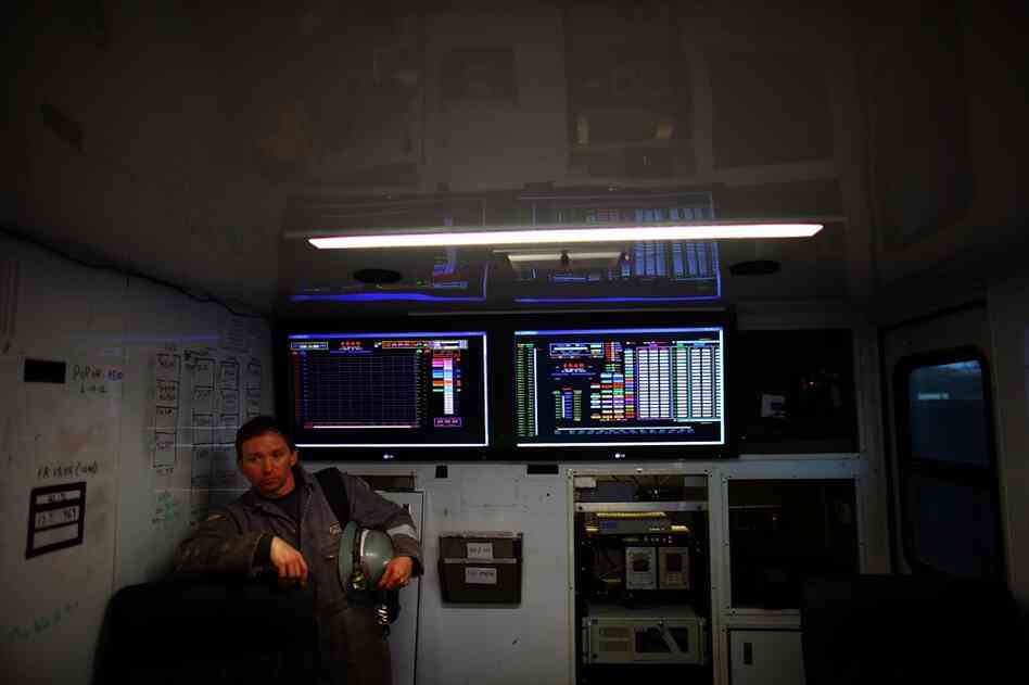 A Chesapeake Energy worker stands next to the control panel that monitors the fracking process.