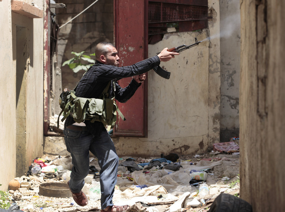 A Sunni gunman fires during clashes in the northern port city of Tripoli, Lebanon on Monday.
