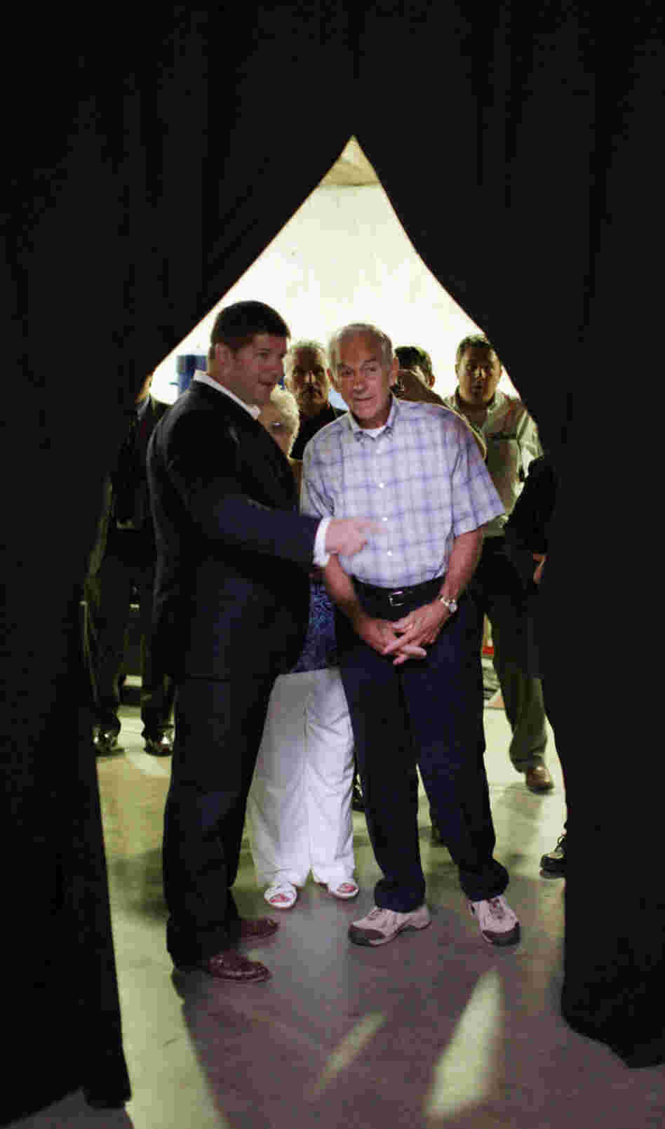 Rep. Ron Paul, R-Texas (right), talks with chief strategist Jesse Benton in Ames, Iowa, on Aug. 13.