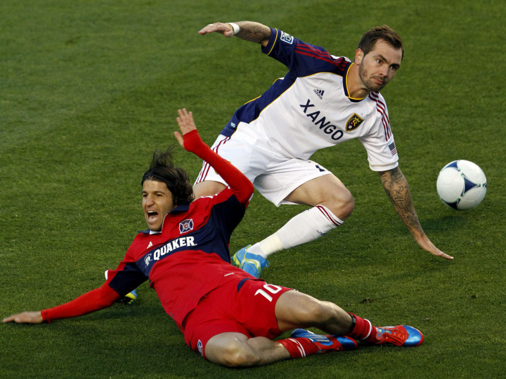Real Salt Lake's Jonny Steele (right) trips Chicago Fire's Sebastian Grazzini during a Major League Soccer matchup. The game ended without a score — one of 11 ties each MLS team is likely to record this season.