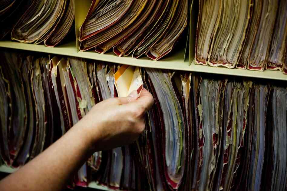 The mystery ailments have prompted the clinic to relocate to a new site 30 minutes away. Here, a staffer sorts through patient files that will need to be moved.