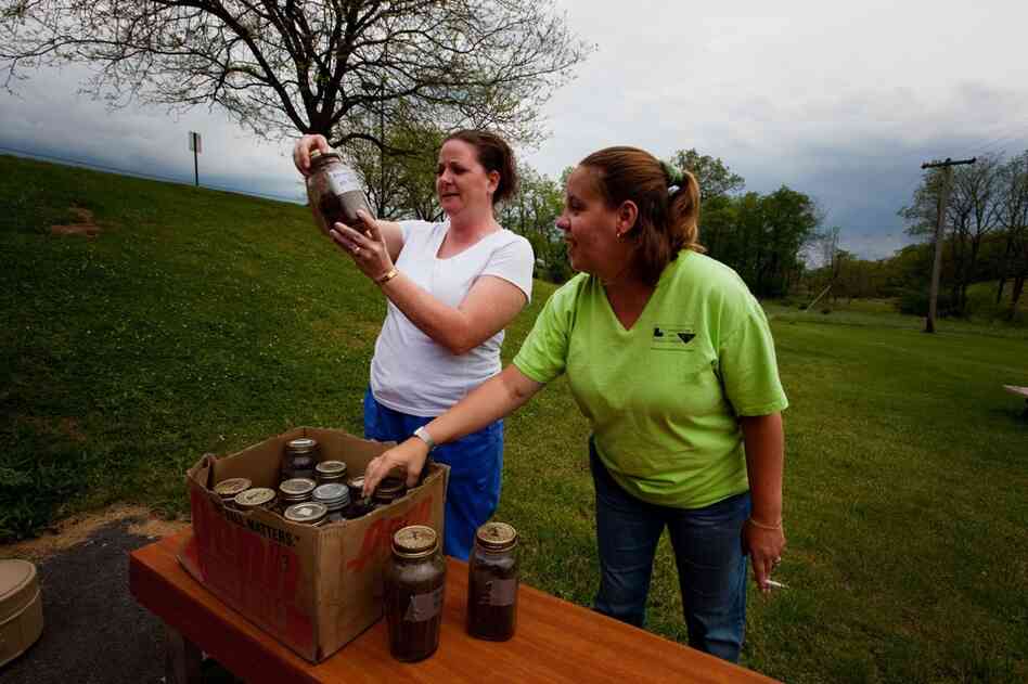 Receptionists Daralyn Fuller (left) and Miranda Thompson examine soil samples gathered outside the clinic.