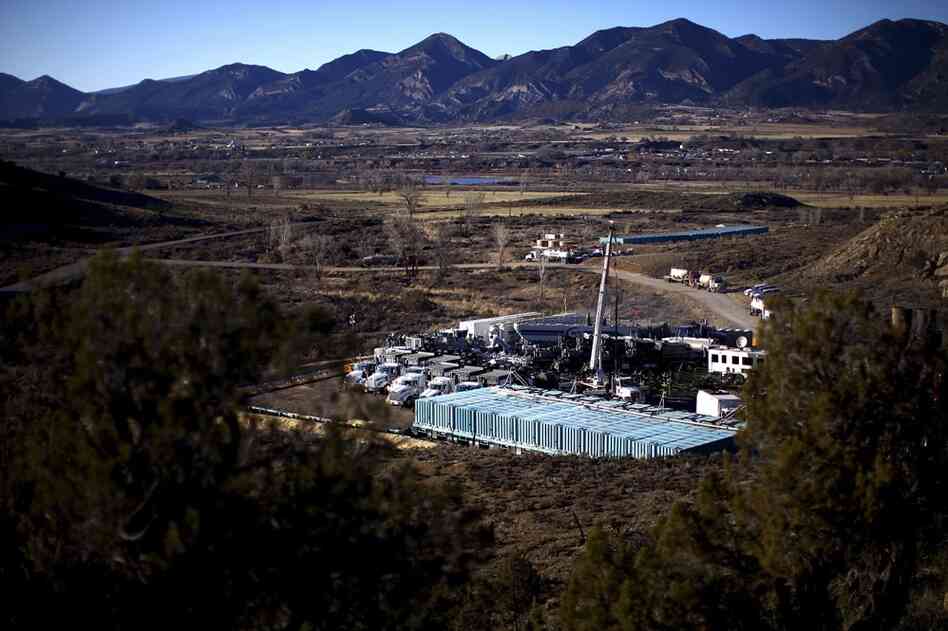 Trucks, water tanks and fracking equipment amassed on a gas pad near the town of Silt and the Grand Hogback Mountain Range.