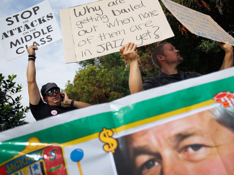Standing behind a banner with a picture of J.P. Morgan Chairman and CEO James Dimon, protesters gathered outside the bank's annual meeting today in Tampa. Standing behind a banner with a picture of J.P. Morgan Chairman and CEO James Dimon, protesters gathered outside the bank's annual meeting today in Tampa.