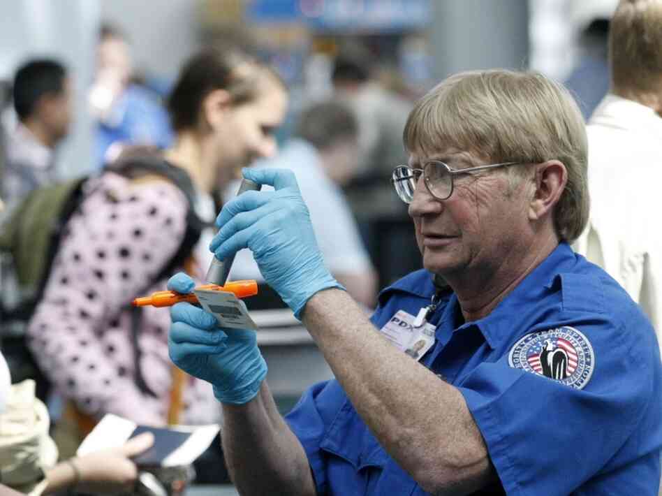 Despite the multiple layers of security at airports, terrorists still often target planes. But terrorism analysts say they are also concerned about soft targets. Here, a Transportation Security Administration agent looks at an identity card at the Portland International Airport earlier this month.