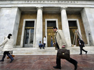 People walk past the Bank of Greece headquarters in Athens. People walk past the Bank of Greece headquarters in Athens.