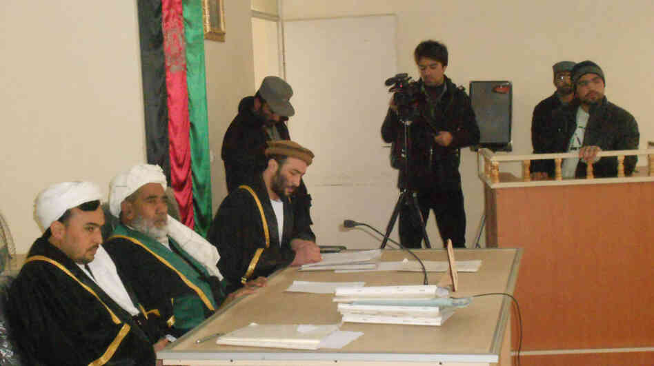 Afghanistan is struggling to develop its court system, and public trials are still relatively rare. Here, an Afghan man named Mahmood (standing, right) listens to a court judge during his trial in the western city of Herat on Jan. 24. He had photos of NATO bases in Afghanistan and was sentenced to 16 years for spying for Iran. Afghanistan is struggling to develop its court system, and public trials are still relatively rare. Here, an Afghan man named Mahmood (standing, right) listens to a court judge during his trial in the western city of Herat on Jan. 24. He had photos of NATO bases in Afghanistan and was sentenced to 16 years for spying for Iran.