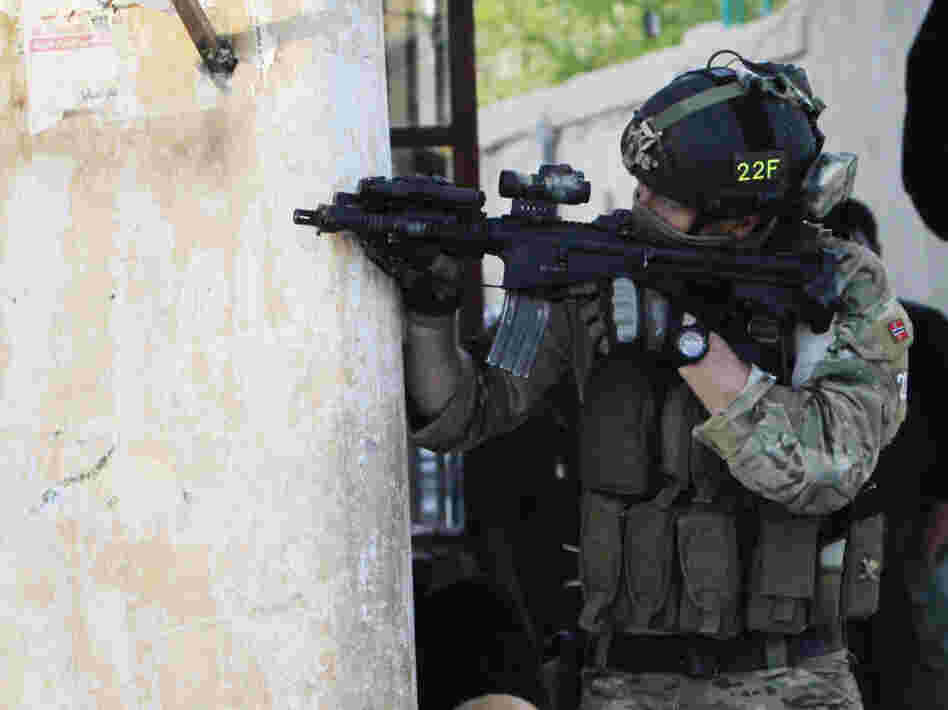 A NATO soldier aims his weapon during a gun battle in Kabul, Afghanistan, in April. NATO is holding a summit in Chicago this weekend, and discussing the future of the alliance is on the agenda.