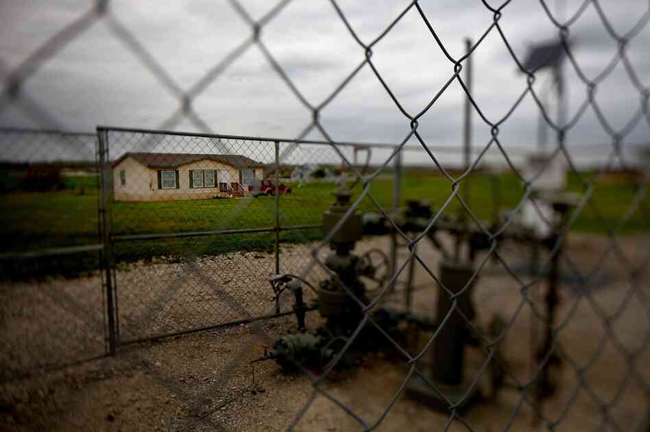 A working gas well head is fenced in just opposite a home. Dish is about 30 miles north of Fort Worth.