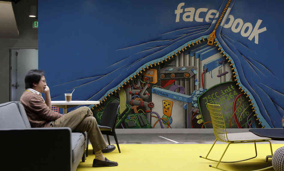 A worker sits in the Facebook office in Menlo Park, Calif. The amount of information Facebook learns about its users seems to have entranced Wall Street.