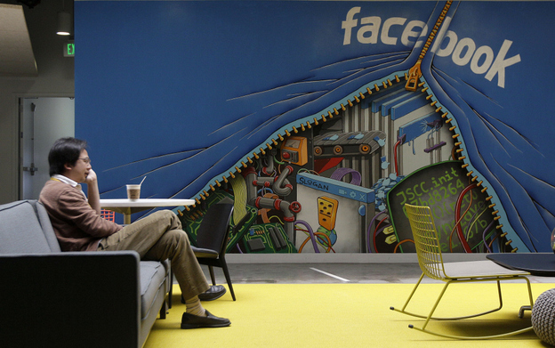 A worker sits in the Facebook office in Menlo Park, Calif. The amount of information Facebook learns about its users seems to have entranced Wall Street.