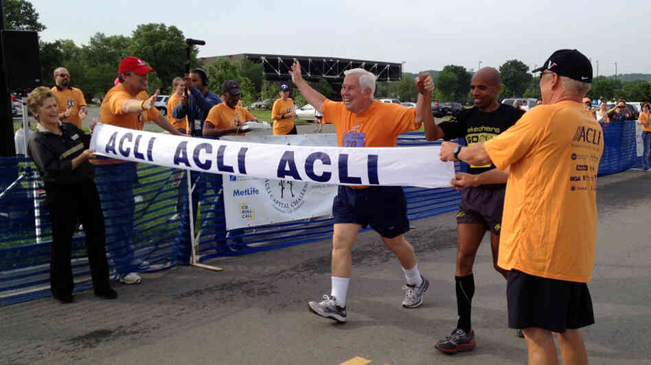 Sen. Dick Lugar, R-Ind., crosses the finish line of the 3-mile Capital Challenge charity race with Olympic marathoner Meb Keflezighi. It was Lugar's 31st race, and his last as a senator after he lost a primary challenge this month.