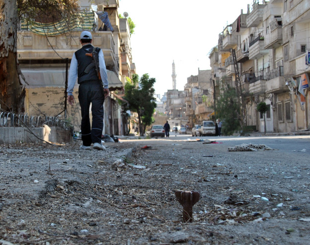 A Syrian rebel walks in Khaldiyeh neighborhood in Homs province, central Syria on Tuesday.