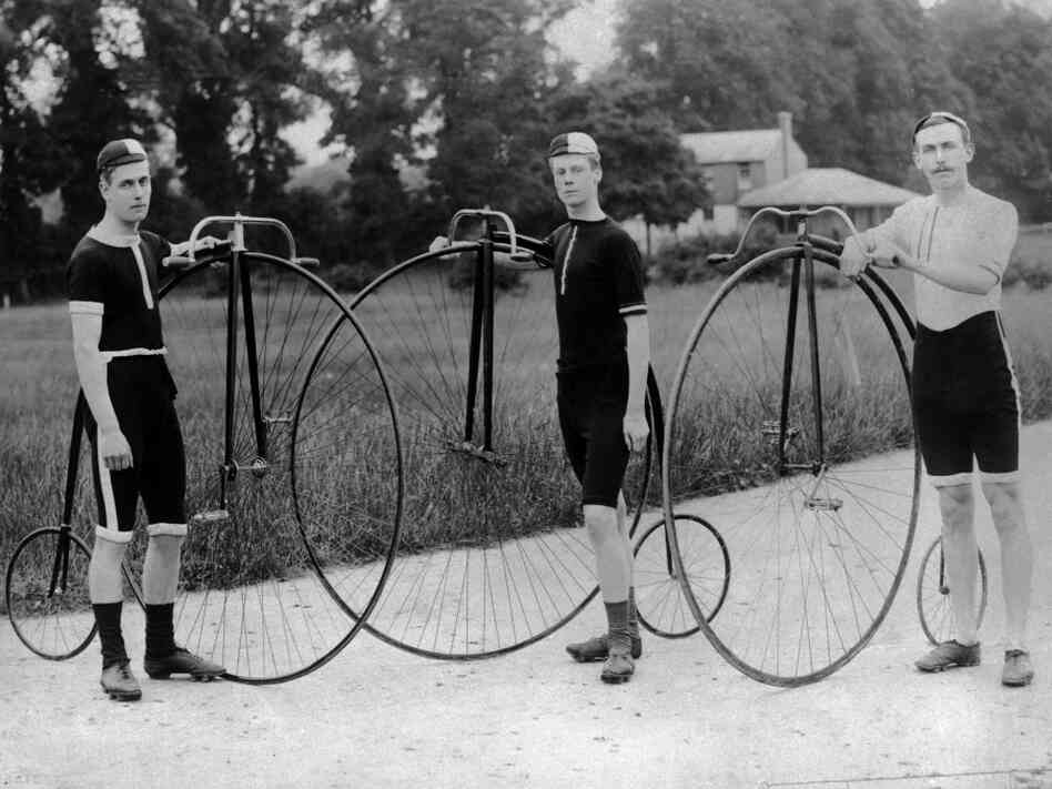 Three men stand with their penny farthing bicycles. Follow their example for Bike to Work Day, and take a photo of yourself and your bike. Then, post the photo to Twitter or Instagram, with the hashtag #NPRbike.