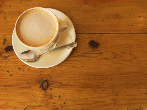 A cup of coffee on a wooden table.