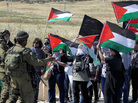 Israeli soldiers stand in front of Palestinian and foreign activists during a demonstration on the 64th anniversary of the creation of the state of Israel, at the Hawara checkpoint outside Nablus, West Bank, on Tuesday. Israeli soldiers stand in front of Palestinian and foreign activists during a demonstration on the 64th anniversary of the creation of the state of Israel, at the Hawara checkpoint outside Nablus, West Bank, on Tuesday.